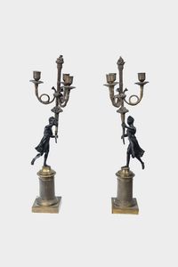 COPPIA DI CANDELIERI - H. cm 57 In bronzo patinato e dorato; corpo con figure maschili reggenti le tre luci