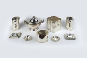 LOTTO DI NOVE OGGETTI IN ARGENTO - Peso gr 7573 8 Composto da: - 1 centrotavola con manici e coperchio con presa geometrica e base circolare. Peso  [..]