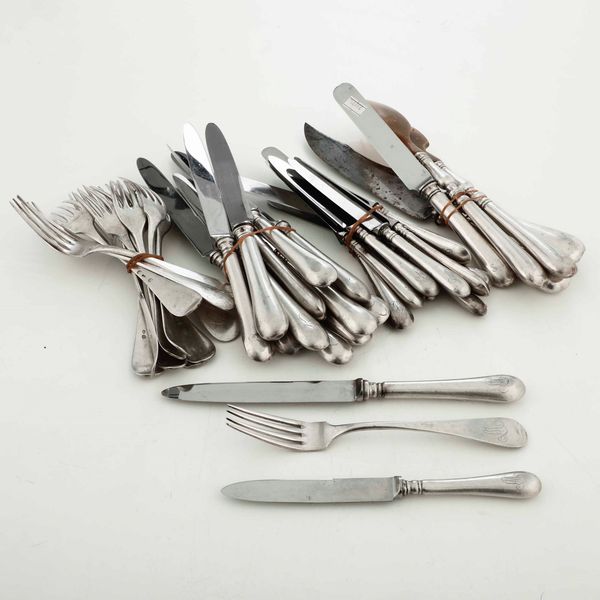 Lotto composto da 4 posate da portata, 12 forchette, 12 coltelli, 11 coltelli da frutta (5 uguali ai coltelli grandi e 6 diversi) ed un coltello in argento  - Asta Argenti - Associazione Nazionale - Case d'Asta italiane