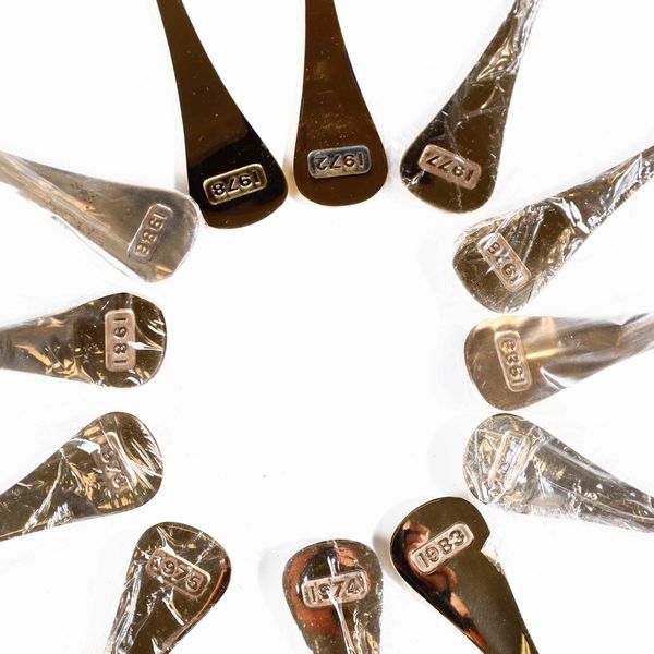 Dodici cucchiai con decorazioni floreali. Argento sterling dorato e smaltato. Annelise Bjrner per Georg Jensen Danimarca, XX secolo  Annate diverse entro scatole originali  - Asta Argenti - Associazione Nazionale - Case d'Asta italiane