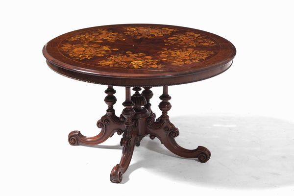 Tavolo in legno intagliato con piano lastronato ed intarsiato a motivi floreali in varie essenze. XIX-XX secolo  - Asta Antiquariato Settembre - Associazione Nazionale - Case d'Asta italiane