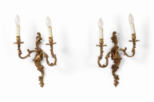 Coppia di appliques stile Luigi XV in metallo dorato a due luci, secolo XX  - Asta Antiquariato Settembre - Associazione Nazionale - Case d'Asta italiane