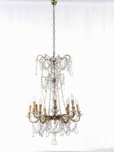 Coppia di lampadari a dodici luci in metallo dorato e pendenti in cristalli. XIX-XX secolo  - Asta Antiquariato Settembre - Associazione Nazionale - Case d'Asta italiane
