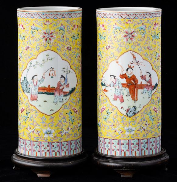 Coppia di vasi cilindrici in porcellana Famiglia Rosa con scene di vita comune entro riserve sagomate e decori a fiore di loto su fondo giallo, Cina, Dinastia Qing, XIX secolo  - Asta Arte Orientale   - Associazione Nazionale - Case d'Asta italiane
