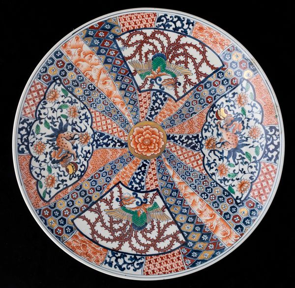 Grande piatto in porcellana con figure di fenici e cani di Pho entro riserve, Giappone, periodo Meiji (1868-1912)  - Asta Arte Orientale   - Associazione Nazionale - Case d'Asta italiane