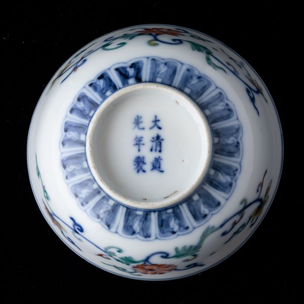 Piccola ciotola in porcellana a smalti Doucai con decoro a fiori loto, pipistrelli e simboli taoisti, Cina, Dinastia Qing, XIX secolo  - Asta Arte Orientale   - Associazione Nazionale - Case d'Asta italiane