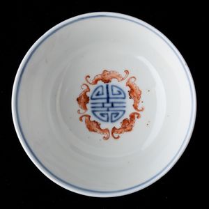 Piccola ciotola in porcellana a smalti Doucai con decoro a fiori loto, pipistrelli e simboli taoisti, Cina, Dinastia Qing, XIX secolo  - Asta Arte Orientale   - Associazione Nazionale - Case d'Asta italiane