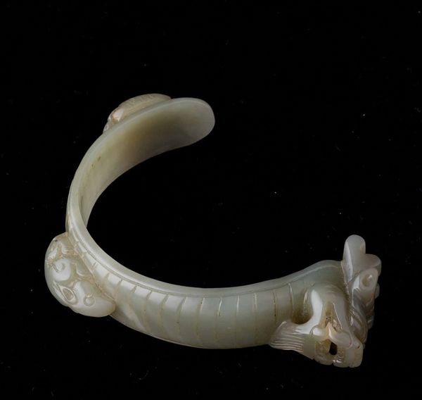 Bracciale scolpito in giada Celadon con figura di drago e animali a rilievo, Cina, Dinastia Qing, XIX secolo  - Asta Fine chinese works of art - Associazione Nazionale - Case d'Asta italiane