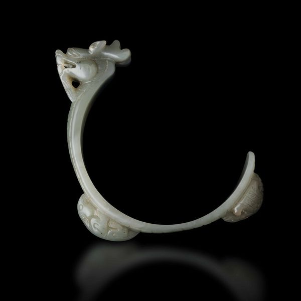 Bracciale scolpito in giada Celadon con figura di drago e animali a rilievo, Cina, Dinastia Qing, XIX secolo  - Asta Fine chinese works of art - Associazione Nazionale - Case d'Asta italiane