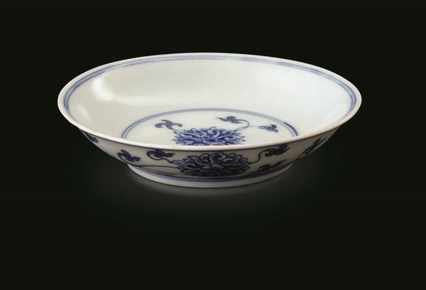 Piccolo piatto in porcellana bianca e blu con decoro a fiori di loto, Cina, Dinastia Qing, marca e del periodo Kangxi (1662-1722)  - Asta Fine chinese works of art - Associazione Nazionale - Case d'Asta italiane