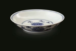Piccolo piatto in porcellana bianca e blu con decoro a fiori di loto, Cina, Dinastia Qing, marca e del periodo Kangxi (1662-1722)  - Asta Fine chinese works of art - Associazione Nazionale - Case d'Asta italiane