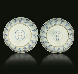 Coppia di piatti in porcellana bianca e blu con scene di caccia e decori floreali, Cina, Dinastia Qing, epoca Kangxi (1662-1722)  - Asta Fine chinese works of art - Associazione Nazionale - Case d'Asta italiane