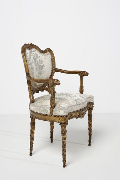 MANIFATTURA DEL XVIII-XIX SECOLO : Poltrona in legno dorato e intagliato, schienale a scudo contornato da decorazione a fascia di alloro, braccioli terminanti in teste leonine, gambe a faretra con decorazione a pampini e grappoli d'uva  - Asta Asta 379 | ARTE ANTICA E DEL XIX SECOLO - Dipinti antichi e antiquariato  Online - Associazione Nazionale - Case d'Asta italiane