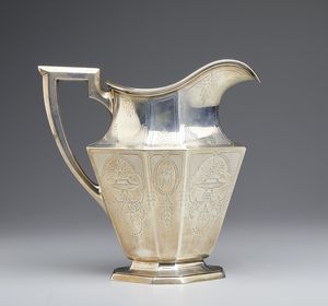 ARGENTIERE INGLESE DEL XX SECOLO - Versatoio in argento sterling a corpo sfaccettato con motivi floreali incisi e monogramma nella fascia centrale