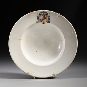 MANIFATTURA DI FAENZA DEL XVI-XVII SECOLO - Piatto da parata in maiolica bianca decorato con stemma cardinalizio