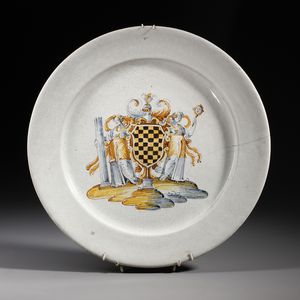 MANIFATTURA DI FAENZA DEL XVI-XVII SECOLO - Piatto in maiolica compendiaria raffigurante stemma nobiliare affiancato da due figure allegoriche