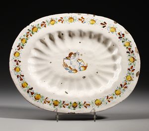 MANIFATTURA CENTROITALIANA DEL XVII SECOLO - Piatto ovale in maiolica compendiaria con putto al centro e ghirlanda lungo il bordo