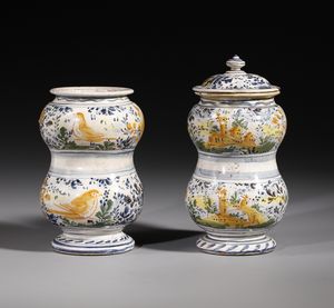 MANIFATTURA EMILIANA O PESARESE DEL XVIII SECOLO - Coppia di albarelli in maiolica policroma di cui uno con coperchio, con decorazioni fitomorfe, a paesi e con figure di volatili lungo il corpo