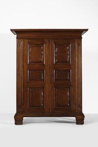 MANIFATTURA ITALIANA DEL XVIII SECOLO - Armadio in noce a due ante, fronte, fianchi e montanti pannellati e riquadrati, piedi a mensola