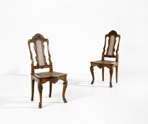 MANIFATTURA VENETA DEL XVIII-XIX SECOLO - Coppia di sedie in noce, di linea mossa e schienale a giorno, con cartella sagomata, gambe arcuate terminanti in piedi caprini, sedute e schienali incannucciati