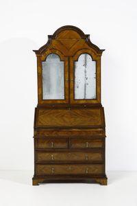 MANIFATTURA VENETA DEL XIX SECOLO - Cassettone a ribalta con alzata lastronato in noce, cimasa di forma mossa, anta calatoia, fronte dritto a tre ordini di cassetti (di cui uno composto da due singoli), piedi a mensola