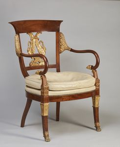MANIFATTURA DEL XX SECOLO - Poltrona in stile Impero con decorazioni in legno dorato, schienale con fregio in forma di cigni, braccioli ricurvi terminanti con testa d'aquila, gambe anteriori terminanti su zampe ferine, gambe posteriori a sciabola.