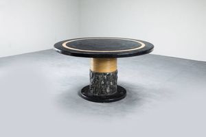 PRODUZIONE ITALIANA - Tavolo rotondo con base in marmo  fusto in pietra scolpita  piano lastronato in marmo. Anni '70 cm 77x130
