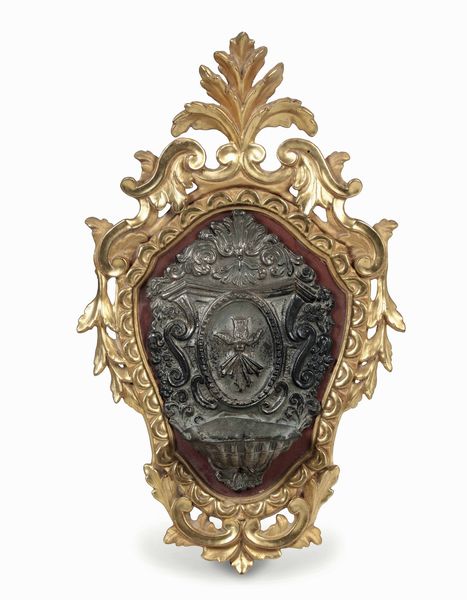 Acquasantiera in metallo sbalzato con cornice in legno intagliato e dorato. XVIII secolo  - Asta Dimore italiane - Associazione Nazionale - Case d'Asta italiane