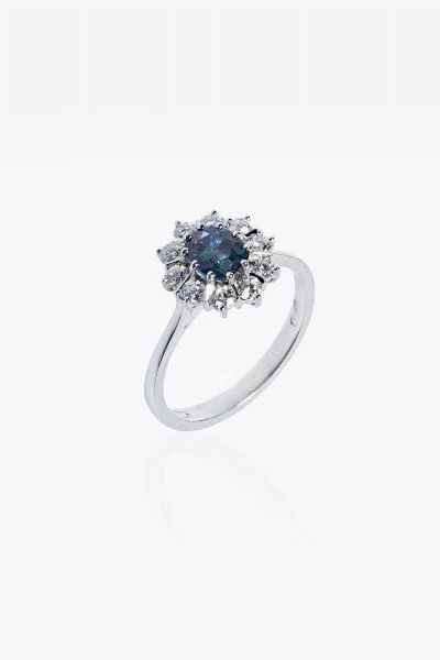 ANELLO : Peso gr 3 2 Misura 15 (55) in oro bianco  sommit a margherita  al centro zaffiro taglio ovale di ct 0 90 ca  contornato da diamanti taglio brillante per totali ct 0 35ca  probabile colore G-H  purezza IF-VVS  - Asta Gioielli - Associazione Nazionale - Case d'Asta italiane