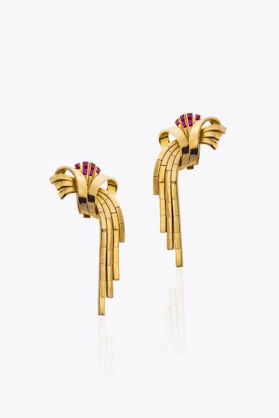 COPPIA DI ORECCHINI : Peso gr 26 8 in oro rosa  anni '40  a clip  con volute terminanti con frange. Rubini sintetici a decoro  - Asta Gioielli - Associazione Nazionale - Case d'Asta italiane