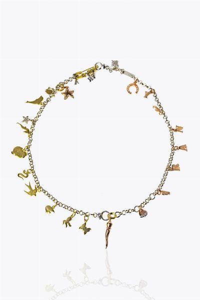 POMELLATO : Peso gr 50 2 Lunghezza cm 45 Girocollo in argento composto da due bracciali modificati della linea Dodo  con 9 charms linea Dodo in oro 9 Kt raffiguranti un corno portafortuna  un cuoricino con diamanti taglio brillante  una stella con diamanti  un ferro di cavallo  sei lettere dell'alfabeto (F-R-A-N-C-Y);  una rana con diamanti taglio brillante; una stellina con diamanti taglio brillante; nove Dodo in oro giallo 18 Kt raffiguranti un granchio  un cavalluccio marino  un dodo  un delfino  un serpente  una rondine  un pesce  un polipo e una farfalla. Al centro spilla da balia in oro giallo non firmata recante tre grani e tre lettere delle linea Dodo con diamanti (F-r-a)  - Asta Gioielli - Associazione Nazionale - Case d'Asta italiane