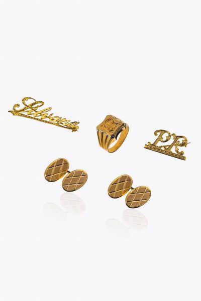 LOTTO DI QUATTRO GIOIELLI : Peso gr 21 9 composto da: -Coppia di gemelli in oro giallo  di forma ovale lavorati a rombi. Peso gr 8 2 -Spilla in oro giallo  a barretta recante la scritta Silvana. Peso gr 3 2 -Spilla in oro giallo recante le lettera PR. Peso gr 2 5 -Anello da uomo in oro giallo e bianco  sommit piatta con incise le lettere AR. Peso gr 8. Misura 22 (62)  - Asta Gioielli - Associazione Nazionale - Case d'Asta italiane