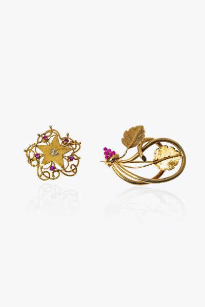LOTTO DI DUE SPILLE : in oro rosa: - a forma di stella con decori a corda e piccoli rubini. Peso gr 6 3. Diam. cm 3 -a forma di voluta con due foglie satinate e piccoli rubini. Peso gr 10 4. Cm 4x3  - Asta Gioielli - Associazione Nazionale - Case d'Asta italiane