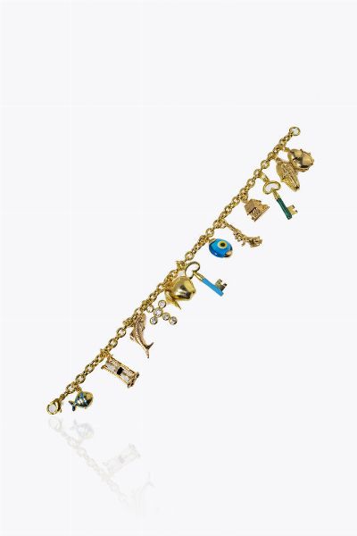 BRACCIALE : Peso gr 24 8 Lunghezza cm 17 in oro giallo con 12 charms pendenti in oro 18 Kt e a bassa caratura  raffiguranti: una coccinella smaltata  una pannocchia  due chiavi in smalto  una casetta  un coniglio  una murrina in vetro  una mela  una croce con gemme sintetiche  un pesce  una clessidra e un pesce smaltato.  - Asta Gioielli - Associazione Nazionale - Case d'Asta italiane