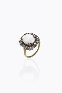 ANELLO - Peso gr 4 5 Misura 15 (55) in oro a bassa caratura ed argento  al centro opale bianco taglio cabochon  contornato  [..]