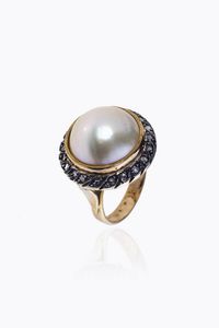ANELLO - Peso gr 12 1 Misura 13 in oro a bassa caratura ed argento  al centro perla mab  contornata da rosette di diam [..]