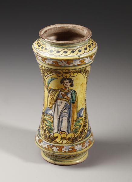 MANIFATTURA DI COLLESANO DEL XVII SECOLO : Albarello in maiolica policroma di forma a rocchetto, sul fronte figura di santa martire entro medaglione ovale su fondo giallo, contornato da decori a trofei su fondo blu  - Asta Asta 387 | ARTE ANTICA E DEL XIX SECOLO - DAL RINASCIMENTO AL SIMBOLISMO: OPERE DA COLLEZIONI ITALIANE Tradizionale - Associazione Nazionale - Case d'Asta italiane