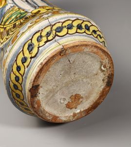 MANIFATTURA DI COLLESANO DEL XVII SECOLO : Albarello in maiolica policroma di forma a rocchetto, sul fronte figura di santa martire entro medaglione ovale su fondo giallo, contornato da decori a trofei su fondo blu  - Asta Asta 387 | ARTE ANTICA E DEL XIX SECOLO - DAL RINASCIMENTO AL SIMBOLISMO: OPERE DA COLLEZIONI ITALIANE Tradizionale - Associazione Nazionale - Case d'Asta italiane