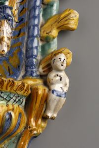 MANIFATTURA CAMPANA DEL XVIII SECOLO : Acquasantiera in maiolica policroma raffigurante al centro l'angelo custode con un fanciullo, lungo i bordi figure di putti e sulla sommit un baldacchino in forma di corona.  - Asta Asta 387 | ARTE ANTICA E DEL XIX SECOLO - DAL RINASCIMENTO AL SIMBOLISMO: OPERE DA COLLEZIONI ITALIANE Tradizionale - Associazione Nazionale - Case d'Asta italiane