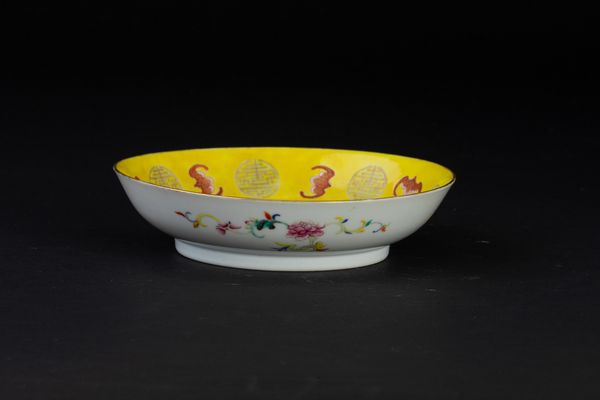 Piatto in porcellana a smalti policromi con figure di pipistrelli e simboli taoisti a fondo giallo, Cina, Dinastia Qing, epoca Guangxu (1875-1908)  - Asta Arte Orientale - Associazione Nazionale - Case d'Asta italiane