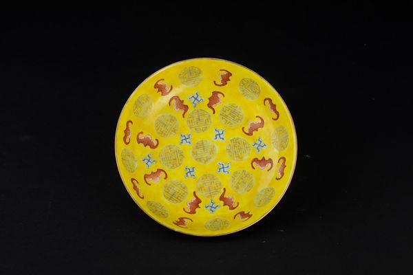 Piatto in porcellana a smalti policromi con figure di pipistrelli e simboli taoisti a fondo giallo, Cina, Dinastia Qing, epoca Guangxu (1875-1908)  - Asta Arte Orientale - Associazione Nazionale - Case d'Asta italiane