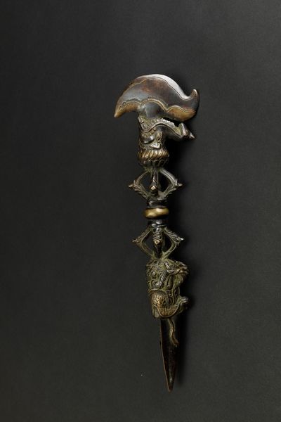 Pugnale rituale Phurgba in bronzo parzialmente dorato con con figura di drago a rilievo e presa a foggia di Vajra, Tibet, XVII secolo  - Asta Arte Orientale - Associazione Nazionale - Case d'Asta italiane