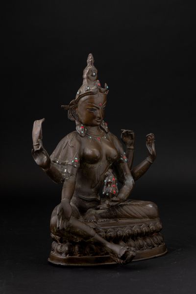 Figura di Tara seduta su doppio fiore di loto in bronzo con innesti in turchese e corallo, Tibet, XIX secolo  - Asta Arte Orientale - Associazione Nazionale - Case d'Asta italiane