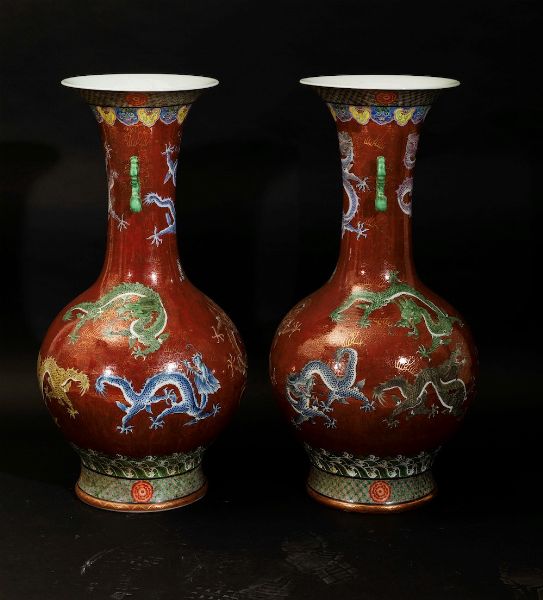Coppia di grandi vasi a doppia ansa in porcellana a smalti policromi con figure di draghi su fondo rosso, Cina, XX secolo  - Asta Arte Orientale - Associazione Nazionale - Case d'Asta italiane