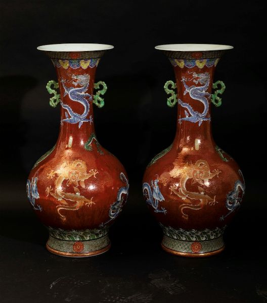 Coppia di grandi vasi a doppia ansa in porcellana a smalti policromi con figure di draghi su fondo rosso, Cina, XX secolo  - Asta Arte Orientale - Associazione Nazionale - Case d'Asta italiane