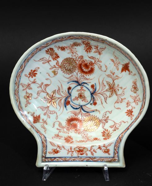 Piccolo piatto a foggia di conchiglia in porcellana Imari con decori floreali, Cina, Dinastia Qing, epoca Kangxi (1662-1722)  - Asta Arte Orientale - Associazione Nazionale - Case d'Asta italiane