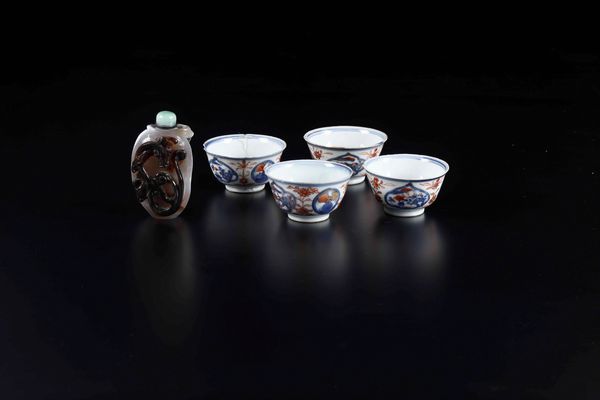 Lotto composto da quattro piccole tazzine in porcellana Imari e una snuff bottle in agata muschiata con figura di draghetto a rilievo, Cina, XX secolo  - Asta Arte Orientale - Associazione Nazionale - Case d'Asta italiane