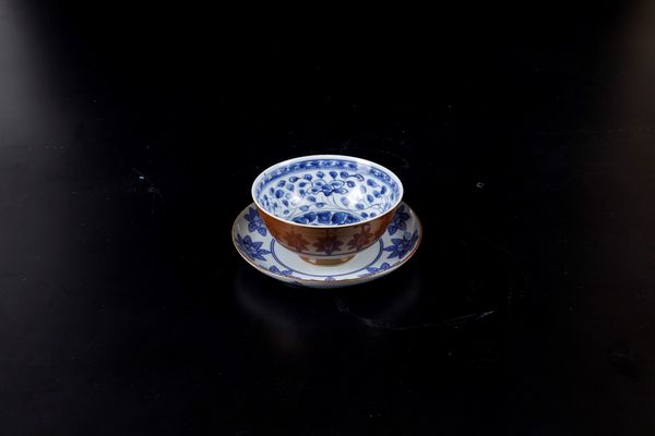 Lotto composto da coppa e piattino in porcellana bianca e blu con decori floreali, Cina, Dinastia Qing, XVII-XVIII secolo  - Asta Arte Orientale - Associazione Nazionale - Case d'Asta italiane