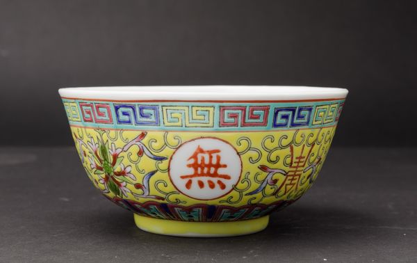 Piccola ciotola in porcellana a smalti policromi con simboli taoisti, fiori di loto e motivo a greca su fondo giallo, Cina, XX secolo  - Asta Arte Orientale - Associazione Nazionale - Case d'Asta italiane