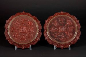 Coppia di piatti in lacca rossa con decoro a rilievo di saggi entro paesaggio, Cina, Dinastia Qing, XIX secolo  - Asta Arte Orientale - Associazione Nazionale - Case d'Asta italiane